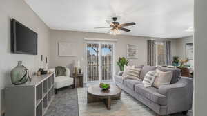 Living room with ceiling fan and light colored carpet