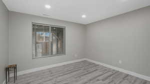 Empty room with light hardwood / wood-style floors