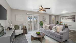 Living room featuring hardwood / wood-style floors, ceiling fan, and a wealth of natural light