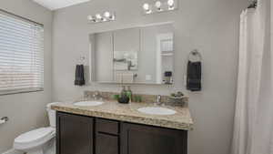 Bathroom featuring vanity, toilet, and a wealth of natural light