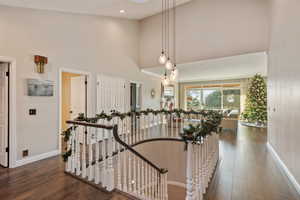 Stairs featuring hardwood / wood-style floors and a high ceiling