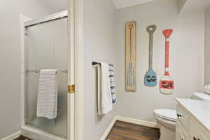 Bathroom with hardwood / wood-style floors, vanity, an enclosed shower, and toilet