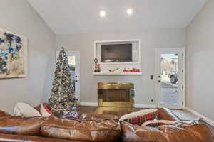 Living room featuring hardwood / wood-style flooring and lofted ceiling