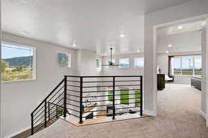 Stairs featuring a mountain view, carpet floors, and a textured ceiling