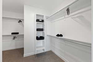 Spacious closet featuring dark carpet