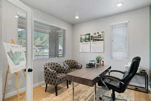 Office space with plenty of natural light and light hardwood / wood-style flooring