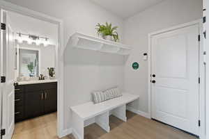 Mudroom featuring sink and light wood-type flooring