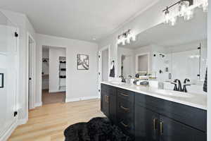 Bathroom with vanity, a shower with shower door, and hardwood / wood-style flooring