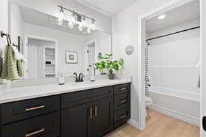 Full bathroom with hardwood / wood-style floors, vanity, toilet, and shower / bath combination with curtain