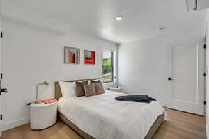 Bedroom featuring a textured ceiling and light wood-type flooring