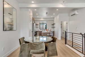 Dining space featuring an AC wall unit, sink, and light hardwood / wood-style floors