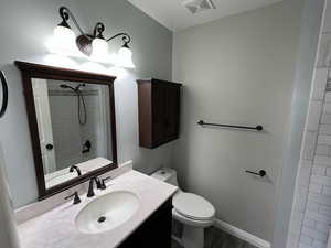 Bathroom with vanity, toilet, and wood-type flooring