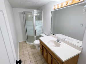 Bathroom with tile patterned flooring, vanity, toilet, and walk in shower