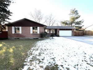 Single story home featuring a lawn and a garage