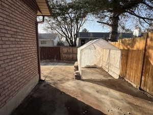 View of patio featuring a storage unit