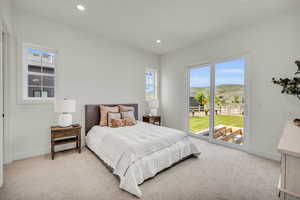 Bedroom with access to exterior, a mountain view, and light colored carpet