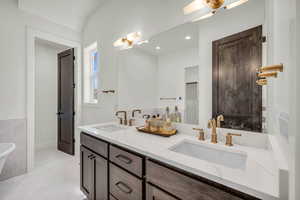 Bathroom featuring vanity, concrete floors, and a tub