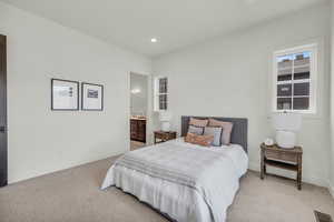 Carpeted bedroom featuring connected bathroom