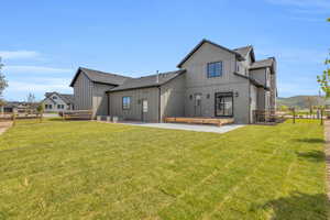 Rear view of property featuring a lawn and a patio