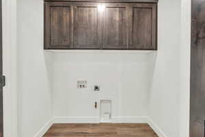 Washroom with cabinets, gas dryer hookup, hookup for a washing machine, hookup for an electric dryer, and wood-type flooring