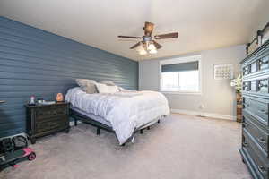 Carpeted bedroom featuring ceiling fan