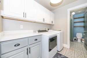 Washroom featuring washer and dryer and cabinets