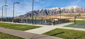 Surrounding community with a mountain view, a yard, and tennis court