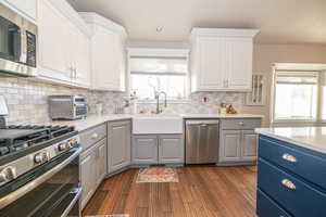 Kitchen featuring white cabinetry, sink, appliances with stainless steel finishes, and tasteful backsplash