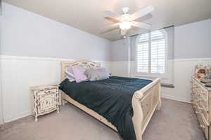 Bedroom with light colored carpet and ceiling fan