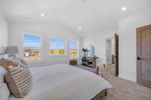 Carpeted bedroom featuring vaulted ceiling