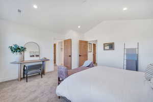 Carpeted bedroom featuring vaulted ceiling