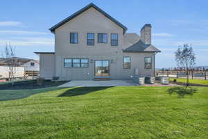 Rear view of house featuring a patio, central AC unit, and a lawn