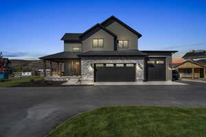 View of front of property featuring a mountain view, a porch, and a garage