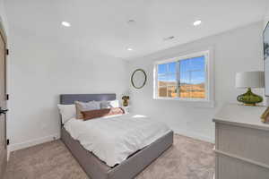 Bedroom featuring light carpet