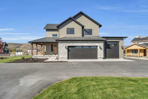 View of front of house with a mountain view, a porch, and a garage