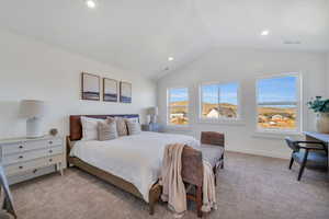 Bedroom with lofted ceiling and light carpet