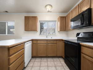 Kitchen featuring kitchen peninsula, sink, crown molding, and black appliances