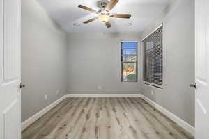 Empty room with a textured ceiling, light hardwood / wood-style flooring, and ceiling fan