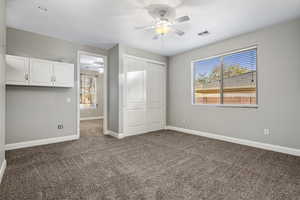 Unfurnished bedroom with carpet, a closet, multiple windows, and ceiling fan