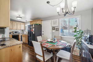 Dining area with dark hardwood / wood-style flooring and a chandelier