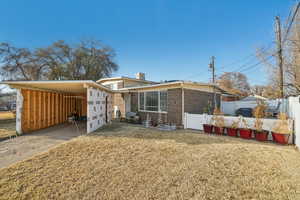 View of front of property with a enclosed carport and a front lawn- siding to be completed on carport with right offer, new completely paid for solar panels