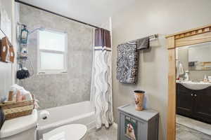 Full bathroom featuring vanity, toilet, and shower / bathtub combination with curtain