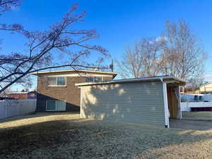 Rear view of house featuring a lawn