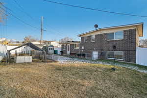 Rear view of property with a yard