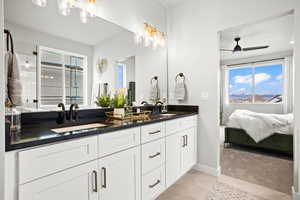 Bathroom with tile patterned floors, ceiling fan, and vanity