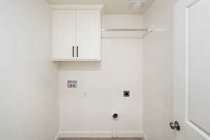 Clothes washing area featuring washer hookup, electric dryer hookup, and cabinets