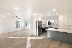 Kitchen featuring sink, light hardwood / wood-style flooring, white cabinetry, kitchen peninsula, and stainless steel appliances