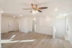 Empty room featuring ceiling fan and light wood-type flooring