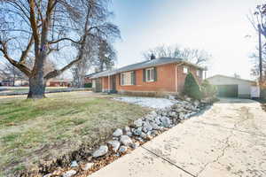 View of side of home featuring a yard, an outbuilding, and a garage