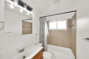 Full bathroom featuring shower / tub combo, vanity, and toilet